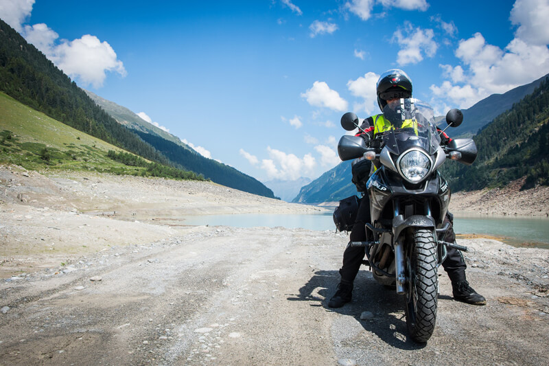 A man riding a motorbike in a mountain valley.