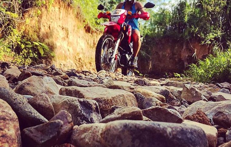 A motorcycle rider on cobbled terrain